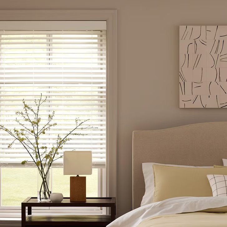 White custom wood and faux wood blinds installed on a wide window
